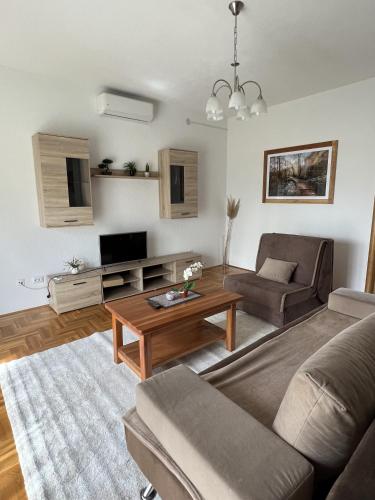 a living room with a couch and a table at Green apartment Plitvice in Rakovica