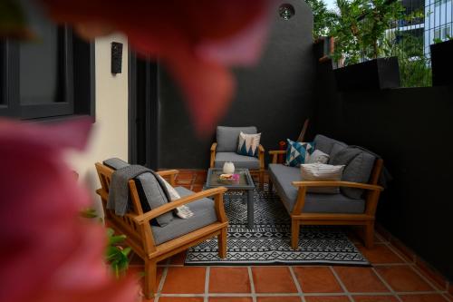 a patio with chairs and a couch on a balcony at Villa Cobojo in Bucerías