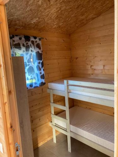 eine Holzhütte mit einem Etagenbett darin in der Unterkunft The Farm in Bouglon