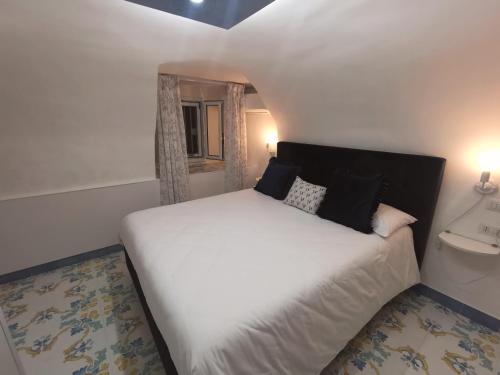 een slaapkamer met een wit bed en een raam bij Domus Myosotis Apartment Napoli in Napels