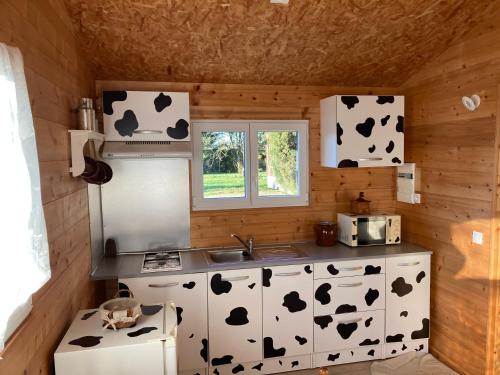 uma cozinha com vacas pretas e brancas na parede em The Farm em Bouglon