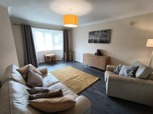 a living room with a couch and a table at Trevithick Gardens, No 47. in Merthyr Tydfil