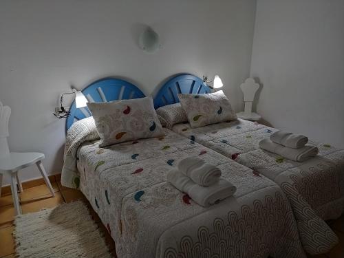 una camera da letto con due letti con asciugamani sopra di Casa rural El Pitañar a Teruel