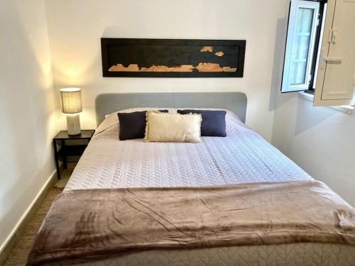 1 dormitorio con 1 cama grande con almohadas azules en Monte do Compadre, en Melides