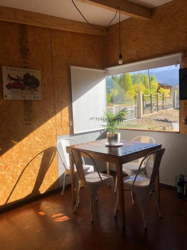 uma sala de jantar com uma mesa e cadeiras e uma janela em Casa de montaña em Potrerillos