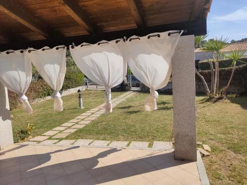 a row of white umbrellas in a yard at Villa Cala Sinzias in Castiadas