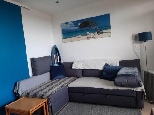 a living room with a couch with blue pillows at The Sweet Cocoon in De Haan