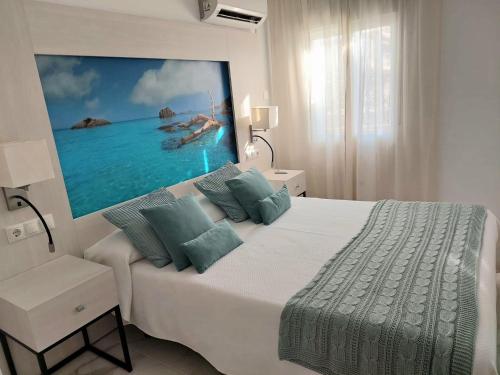 een slaapkamer met een groot bed met een schilderij aan de muur bij Villa Musica in Torremolinos