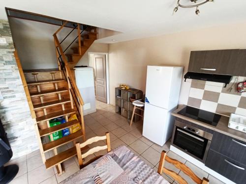 una cocina con electrodomésticos blancos y una escalera de caracol en Casa Bonino, en Prunelli-di-Fiumorbo
