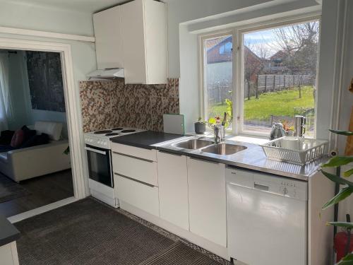 uma cozinha com um lavatório, um fogão e uma janela em Bli Hel em Malmo