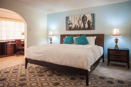 a bedroom with a large bed with blue walls at Seawind Beach Apartments in Montego Bay