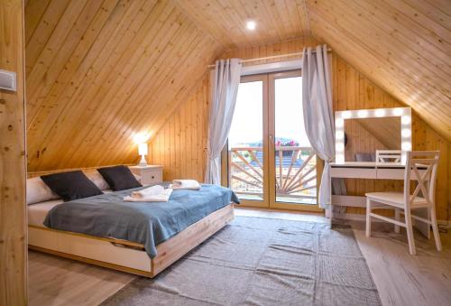 1 dormitorio con cama y ventana grande en Nini House Dudki, en Giże