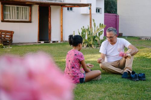 a man and a little girl sitting on the grass at SIGRUM Hostel in San Rafael