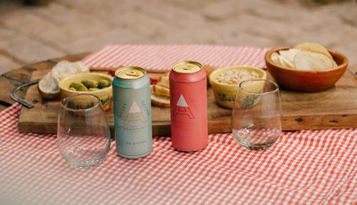 a table with two soda cans and wine glasses at SIGRUM Hostel in San Rafael
