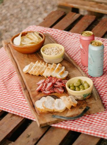 a wooden cutting board with cheese and other foods on a table at SIGRUM Hostel in San Rafael