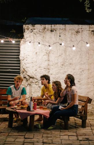 a group of people sitting at a picnic table at SIGRUM Hostel in San Rafael