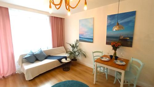 a living room with a couch and a table at Meva Sopot Apartment in Sopot
