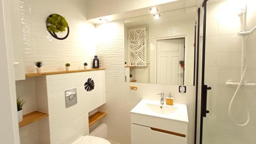 a bathroom with a sink and a toilet and a shower at Meva Sopot Apartment in Sopot