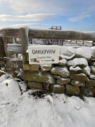 a sign on a stone wall in the snow at Keepers Shepherd hut with Hot Tub in Whitby