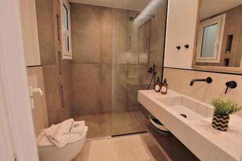 a bathroom with a shower and a toilet and a sink at La Mer Bleue Beachfront Boutique Apartments in Vrachati