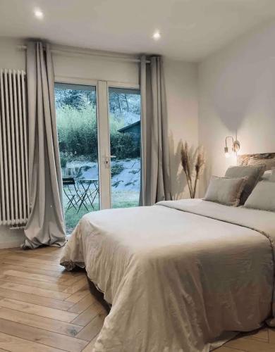 une chambre avec un grand lit et une grande fenêtre dans l'établissement Les Hortensias Chambre indépendante avec sdb et toilettes privées dans une maison en forêt proche du golf et de la plage Entree indépendante avec acces privé, à Le Touquet-Paris-Plage