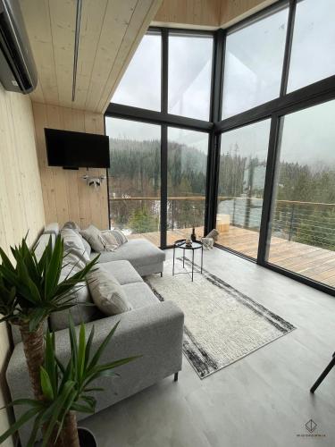 a living room with a couch and a large window at Widokownia Brenna in Brenna