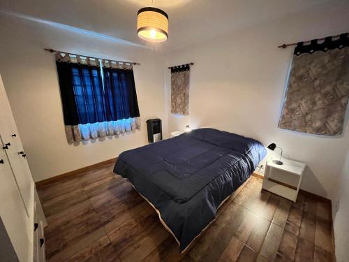 1 dormitorio con 1 cama y suelo de madera en Hermosa casa vacacional a orillas del río en Potrero de los Funes