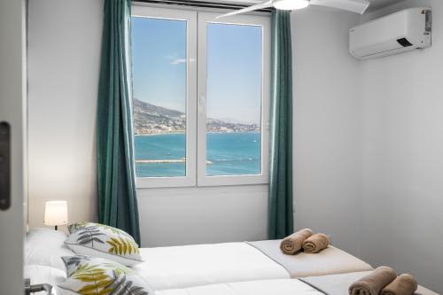 um quarto com uma grande janela com vista para o oceano em Sur Suites Palmeras 10 em Fuengirola