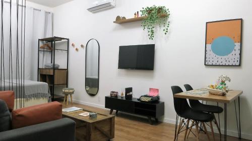 un soggiorno con TV, tavolo e sedie di Apezinho.Loft 3 (Retrô) a Rio de Janeiro
