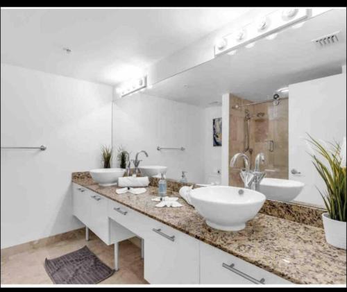 a bathroom with two sinks and a large mirror at Sublime Views 2BR double balcony loft in Miami