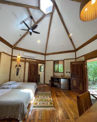 Casita Ylang Ylang في نوسارا: غرفة نوم بسريرين ومروحة سقف