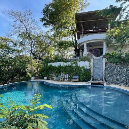 a swimming pool in front of a house at Casita Ylang Ylang in Nosara
