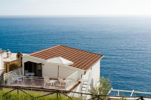 uma casa branca com uma varanda junto ao oceano em Villa Sofia em Praiano