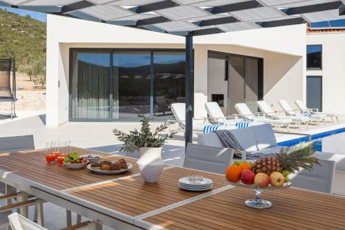 einen Holztisch mit Obst auf einem Haus in der Unterkunft Luxury Villa Dolac by Trogir and Split, complete privacy in untouched nature with infinity massage heated pool in Marina