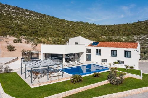 eine Luftansicht eines Hauses mit Pool in der Unterkunft Luxury Villa Dolac by Trogir and Split, complete privacy in untouched nature with infinity massage heated pool in Marina