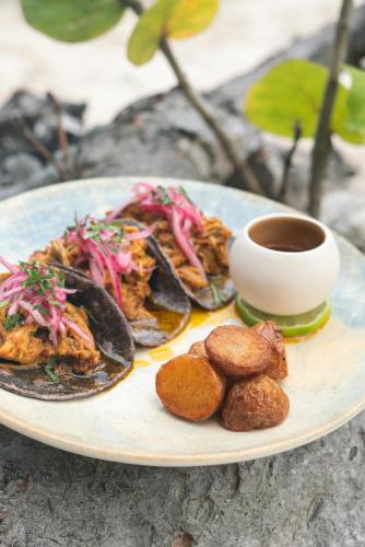 a plate of food on a table with a cup of coffee at Astral Tulum in Tulum