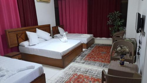 1 Schlafzimmer mit 2 Betten, einem Tisch und einem Stuhl in der Unterkunft ALShawarbi Plaza Hotel in Kairo