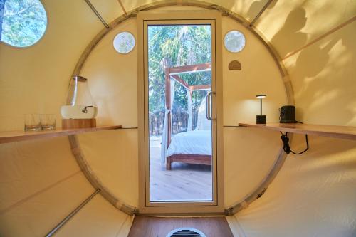 a round mirror in a room with a bedroom at Astral Tulum in Tulum