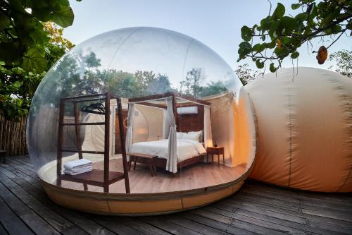 two domes with a bed in them on a deck at Astral Tulum in Tulum