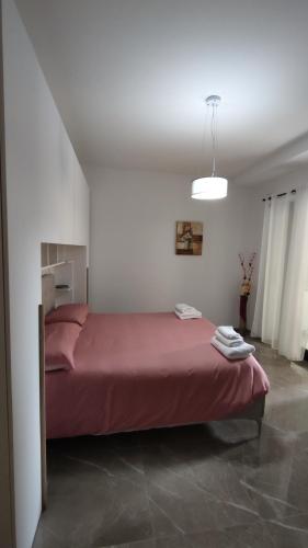 a bedroom with a red bed in a white room at Bruno's House in Pescara