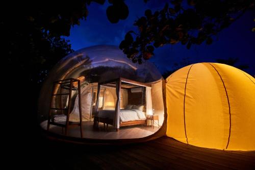 a bedroom in a dome tent at night at Astral Tulum in Tulum