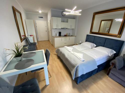 a bedroom with a bed and a desk with a mirror at Apartament Comfort w Świnoujściu in Świnoujście