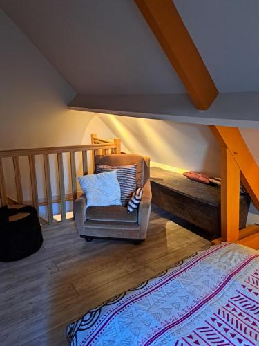 ein Wohnzimmer mit einem Stuhl und einer Treppe in der Unterkunft Chambre d'hôtes Bien-être 