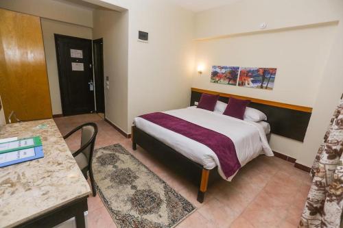 a hotel room with a bed with purple pillows at Jawhara Inn Hotel - فندق الجوهرة سفاجا in Hurghada