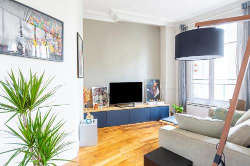 a living room with a couch and a tv at Chambre - Marceau in Courbevoie