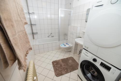 een witte badkamer met een wasmachine bij Ferienwohnung Mark in Villingen-Schwenningen