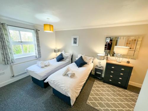 a bedroom with two beds and a mirror at 3 Bedroom Apartment, Free Parking & Fast WiFi, 65 Inch Smart TV in Milton Keynes