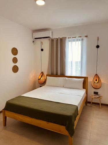 a bed in a bedroom with two lamps on it at Appartement NOAM, Mont Choisy in Mont Choisy