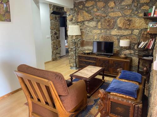 a living room with a couch and a tv at Casa do Avô Grande in Esposende