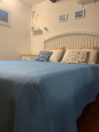 a bed with a blue blanket on top of it at CASABARBARA lerici in Lerici